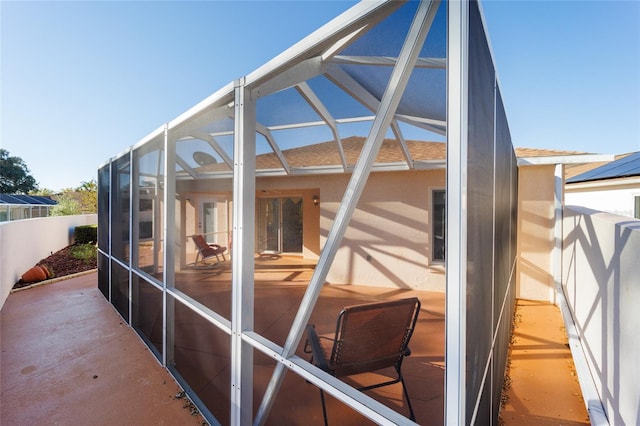 exterior space with glass enclosure, a patio area, a shingled roof, and fence