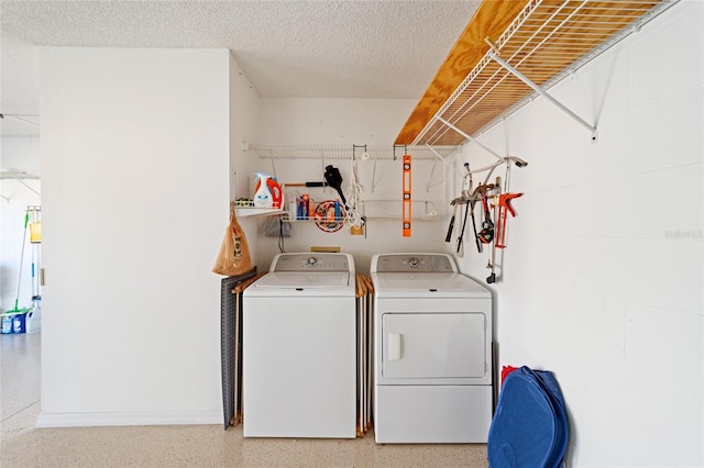 laundry area featuring washer and dryer, laundry area, and a textured ceiling