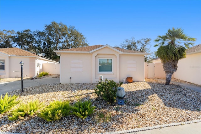view of front of property featuring a gate, stucco siding, and fence