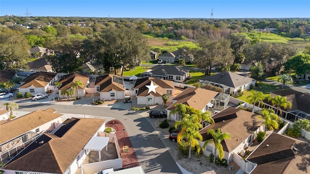 drone / aerial view with a wooded view and a residential view