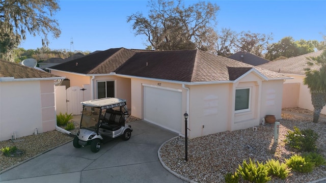 view of side of property with a gate, driveway, a shingled roof, stucco siding, and a garage