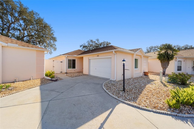 view of front facade with stucco siding, concrete driveway, a garage, and fence