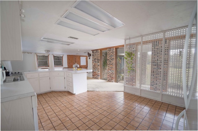 kitchen featuring a sink, a healthy amount of sunlight, white cabinets, and light countertops