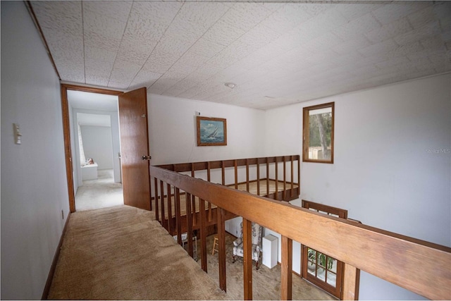 corridor with an upstairs landing and carpet