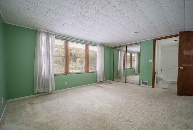 spare room with visible vents, baseboards, and carpet