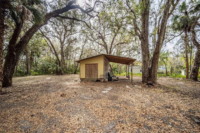 view of yard featuring an outdoor structure and dirt driveway