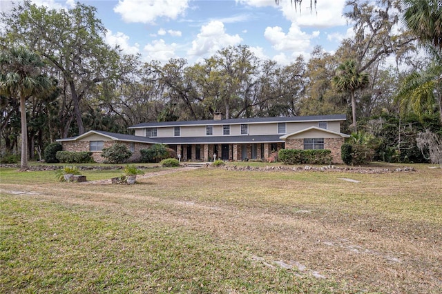 mid-century modern home with brick siding and a front lawn