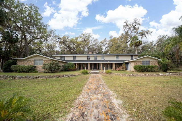 view of front of house with brick siding and a front lawn