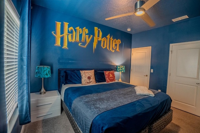 carpeted bedroom with visible vents, ceiling fan, and a textured ceiling