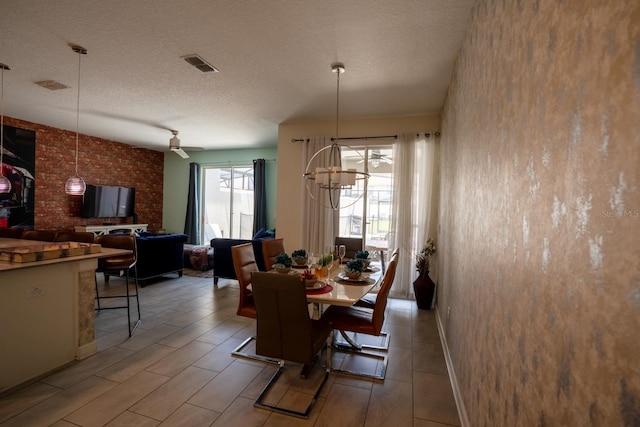 dining space featuring a textured ceiling, wood tiled floor, visible vents, and a notable chandelier