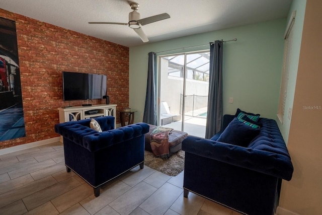 living room with ceiling fan, a textured ceiling, and baseboards