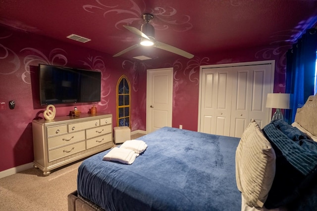 bedroom featuring light carpet, baseboards, visible vents, a ceiling fan, and a closet