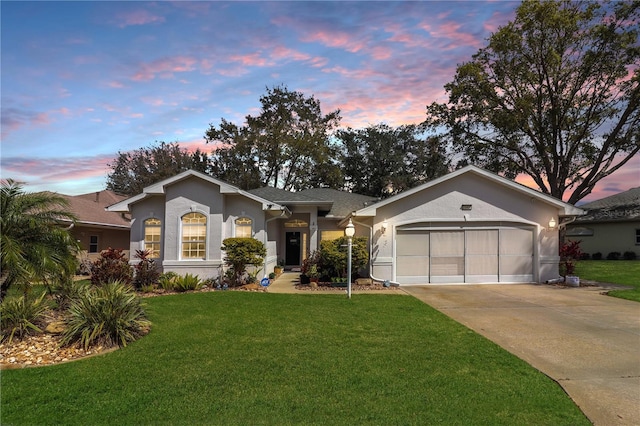 ranch-style house with concrete driveway, an attached garage, a front lawn, and stucco siding