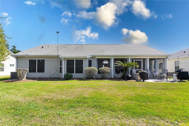 back of house with central AC, roof with shingles, a patio, and a lawn