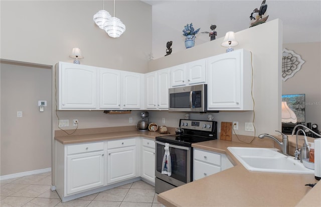 kitchen with light tile patterned floors, light countertops, appliances with stainless steel finishes, and a sink