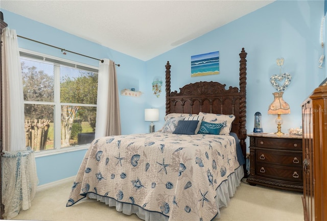 bedroom with lofted ceiling, a textured ceiling, baseboards, and light colored carpet