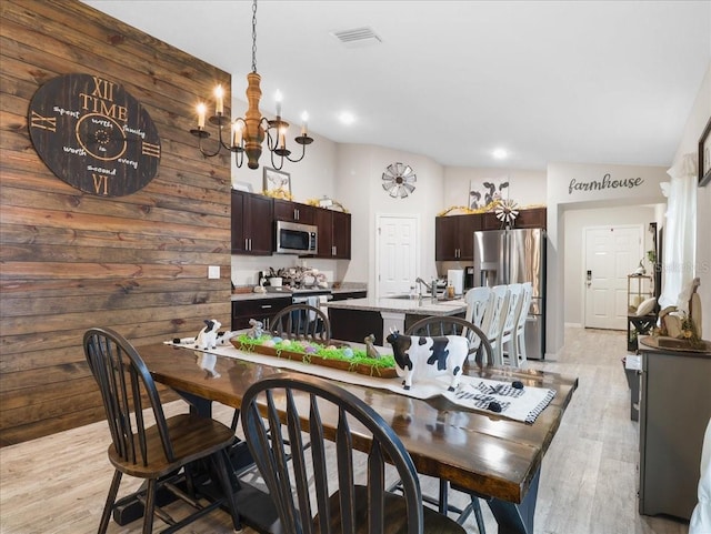 dining space with light wood finished floors, visible vents, a notable chandelier, and recessed lighting