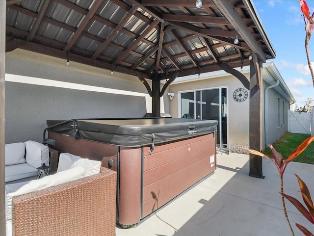 view of patio featuring a hot tub and fence