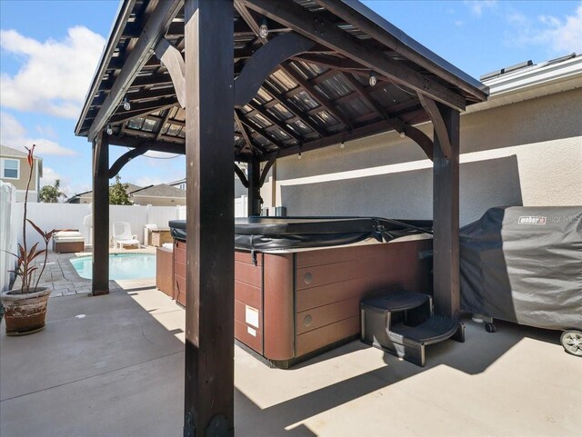 view of patio featuring a fenced in pool, a fenced backyard, a hot tub, and a gazebo