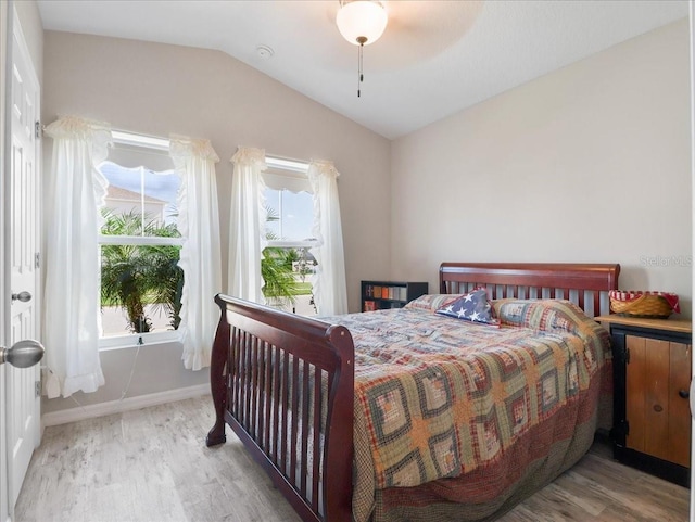 bedroom with lofted ceiling, baseboards, and wood finished floors