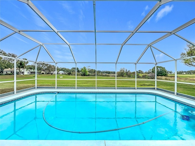 pool with a lanai and a lawn