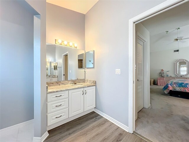 bathroom with vanity, baseboards, a ceiling fan, and ensuite bathroom