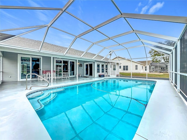 outdoor pool with a patio and glass enclosure