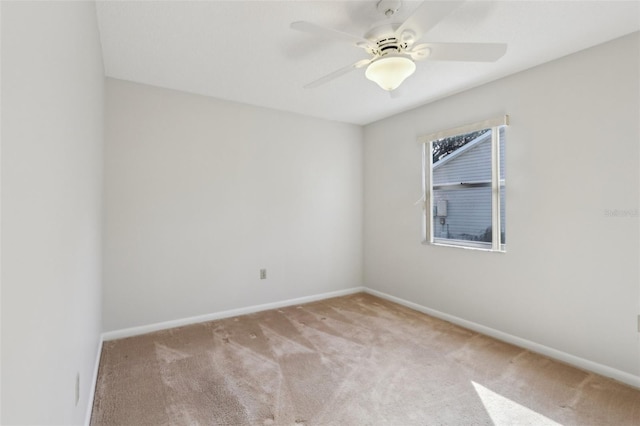 empty room featuring carpet floors, ceiling fan, and baseboards