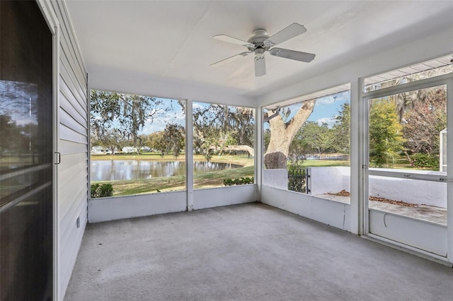 unfurnished sunroom with a ceiling fan and a water view