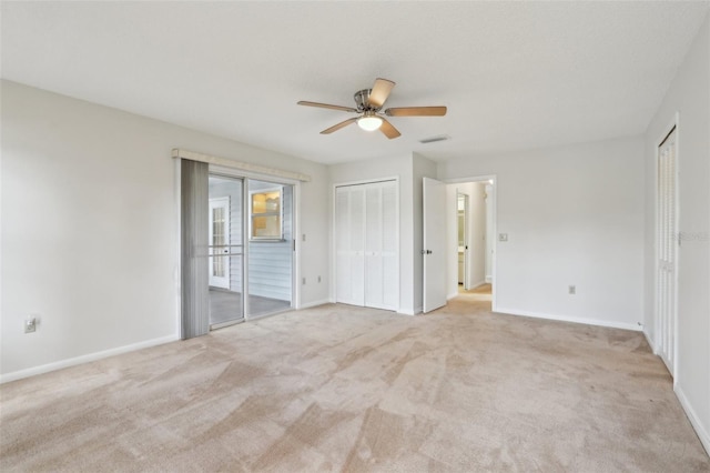 unfurnished bedroom featuring multiple closets, access to outside, light colored carpet, and baseboards