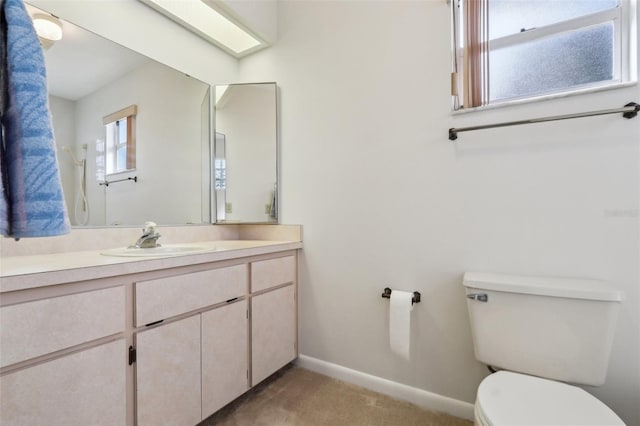 bathroom with baseboards, vanity, and toilet