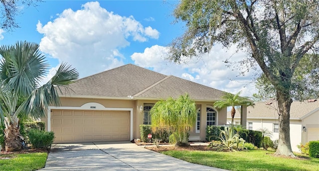 ranch-style home featuring a garage, driveway, roof with shingles, and stucco siding