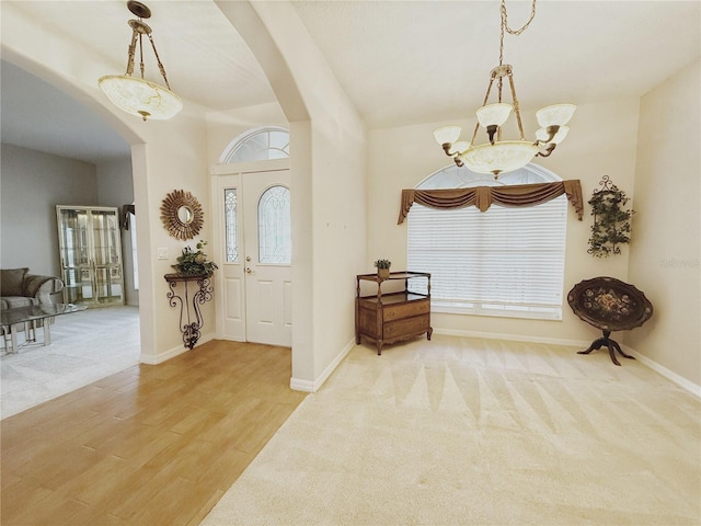 entryway with carpet floors, arched walkways, and baseboards