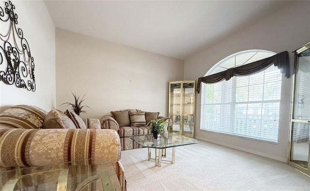 living area with lofted ceiling, carpet, and baseboards