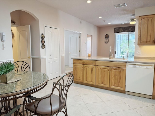 kitchen with arched walkways, light countertops, visible vents, a sink, and dishwasher