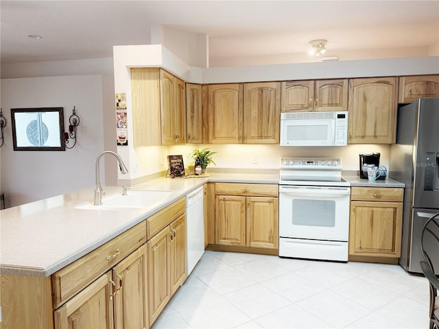 kitchen featuring a peninsula, white appliances, light countertops, and a sink