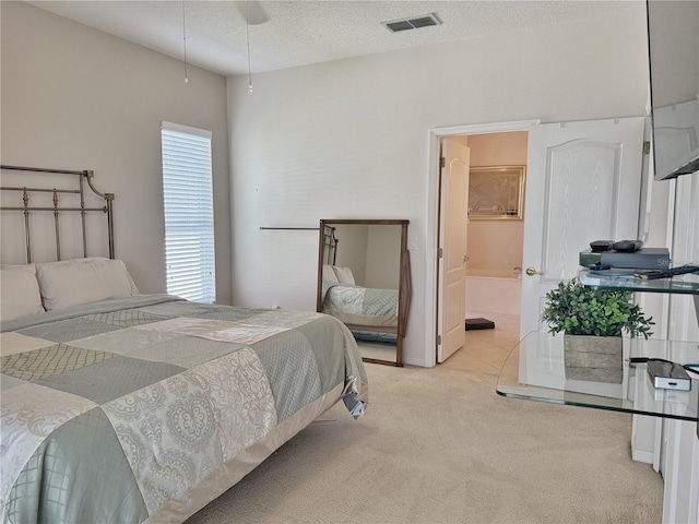 bedroom featuring visible vents, a textured ceiling, and carpet flooring