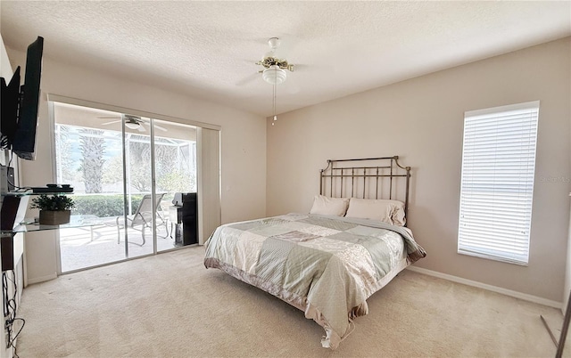 bedroom featuring a textured ceiling, light colored carpet, a ceiling fan, baseboards, and access to outside