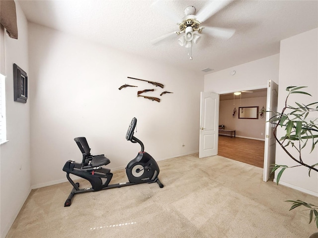 workout room with carpet floors, visible vents, a textured ceiling, and a ceiling fan