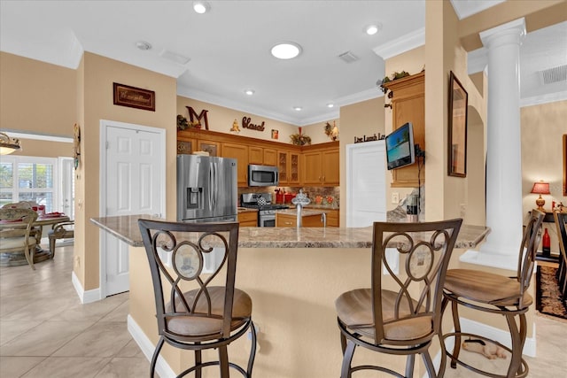 kitchen featuring decorative backsplash, appliances with stainless steel finishes, brown cabinets, ornamental molding, and a peninsula