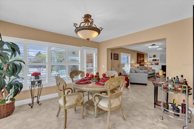 dining room with light tile patterned floors, plenty of natural light, and baseboards