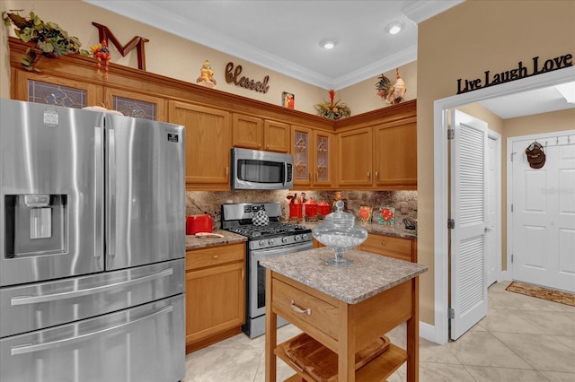 kitchen featuring brown cabinetry, decorative backsplash, glass insert cabinets, appliances with stainless steel finishes, and ornamental molding