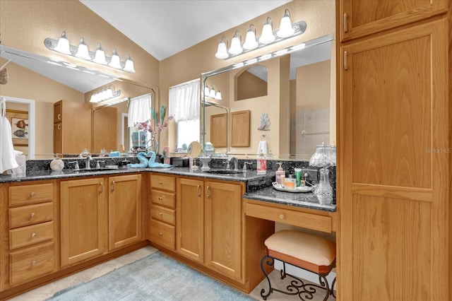 bathroom with lofted ceiling, double vanity, and a sink