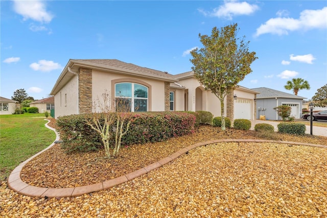 view of front facade with a garage, concrete driveway, a front yard, and stucco siding