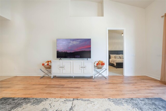 unfurnished living room featuring vaulted ceiling, baseboards, and wood finished floors