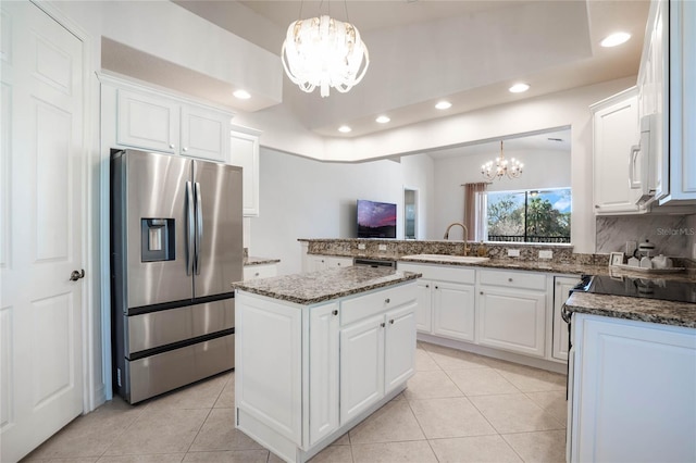 kitchen featuring a peninsula, an inviting chandelier, white cabinetry, stainless steel refrigerator with ice dispenser, and a sink