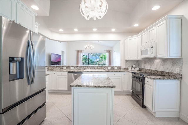 kitchen featuring decorative backsplash, white cabinets, appliances with stainless steel finishes, a notable chandelier, and a sink