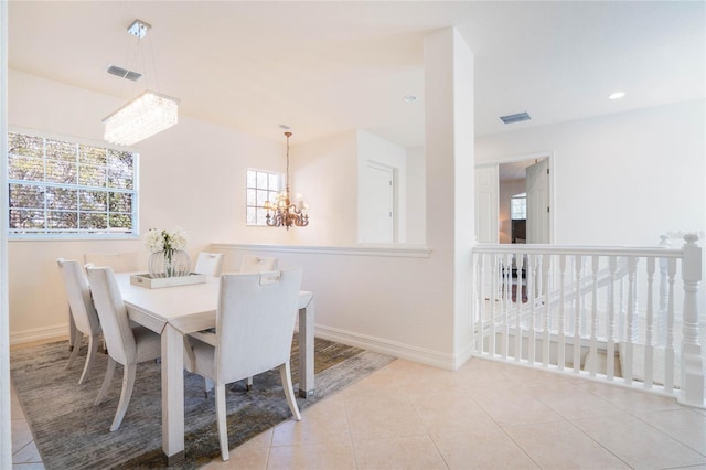 dining room with an inviting chandelier, tile patterned flooring, visible vents, and baseboards