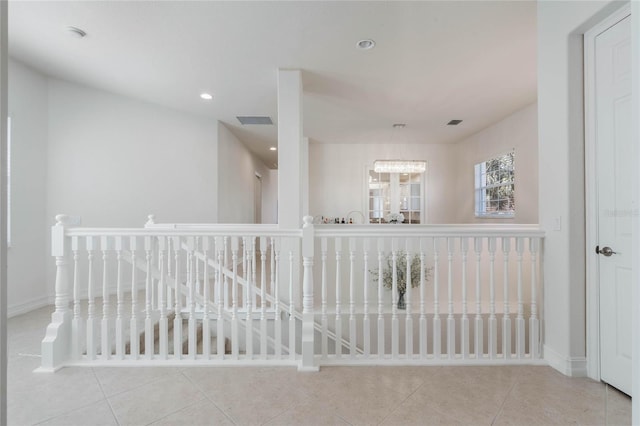 corridor featuring baseboards, tile patterned floors, an upstairs landing, a chandelier, and recessed lighting