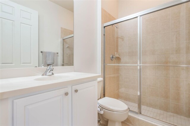 bathroom featuring a stall shower, vanity, and toilet